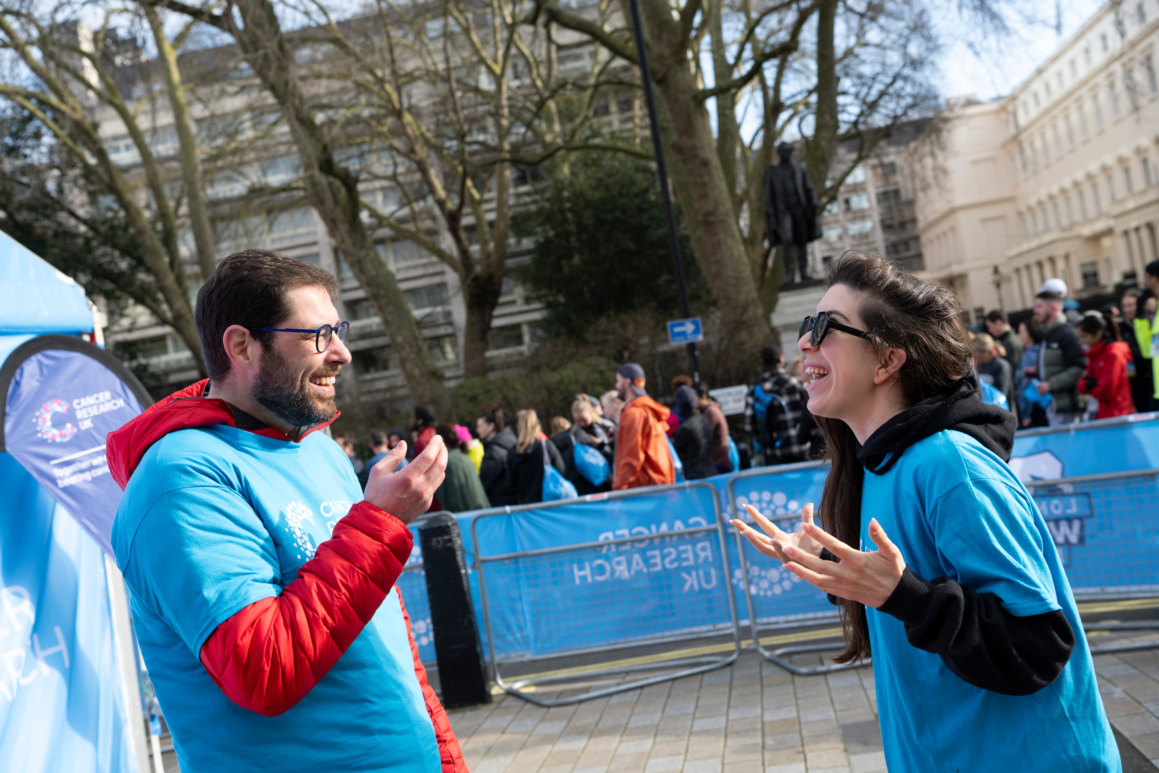Two event volunteers smiling, talking to each other. Volunteers at Winter Run 2024.