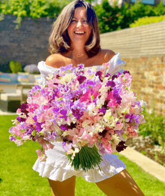 Picture of Dame Deborah James holding a bunch of colourful flowers.