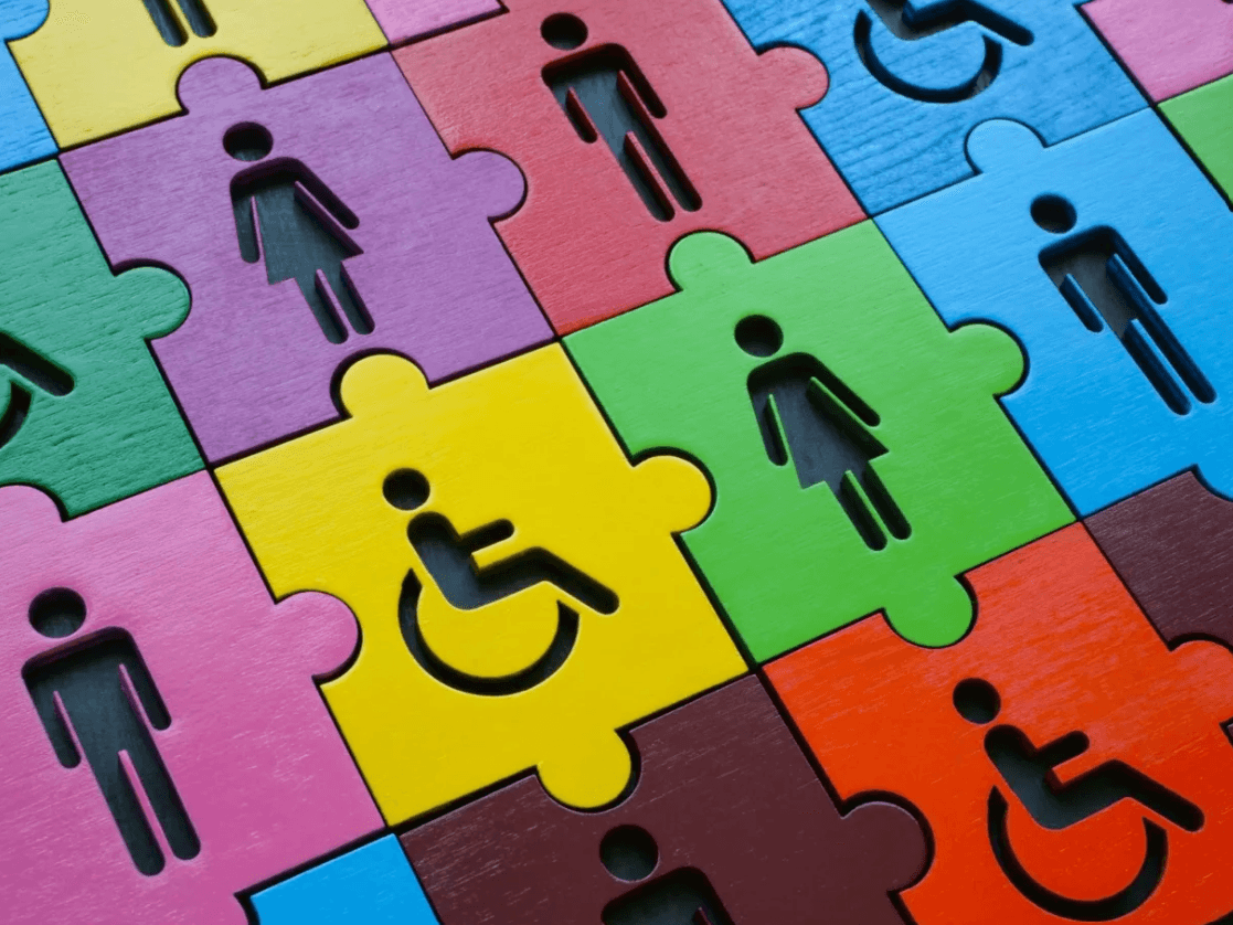 Colorful puzzle pieces with icons of people and accessibility symbols, representing diversity and inclusion.