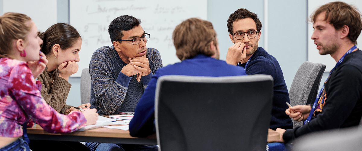Researchers at a table talking to each other.