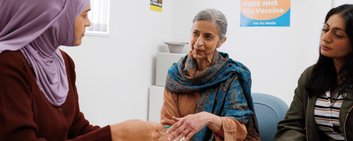 Doctor at the GP surgery talking to the patient and her carer.