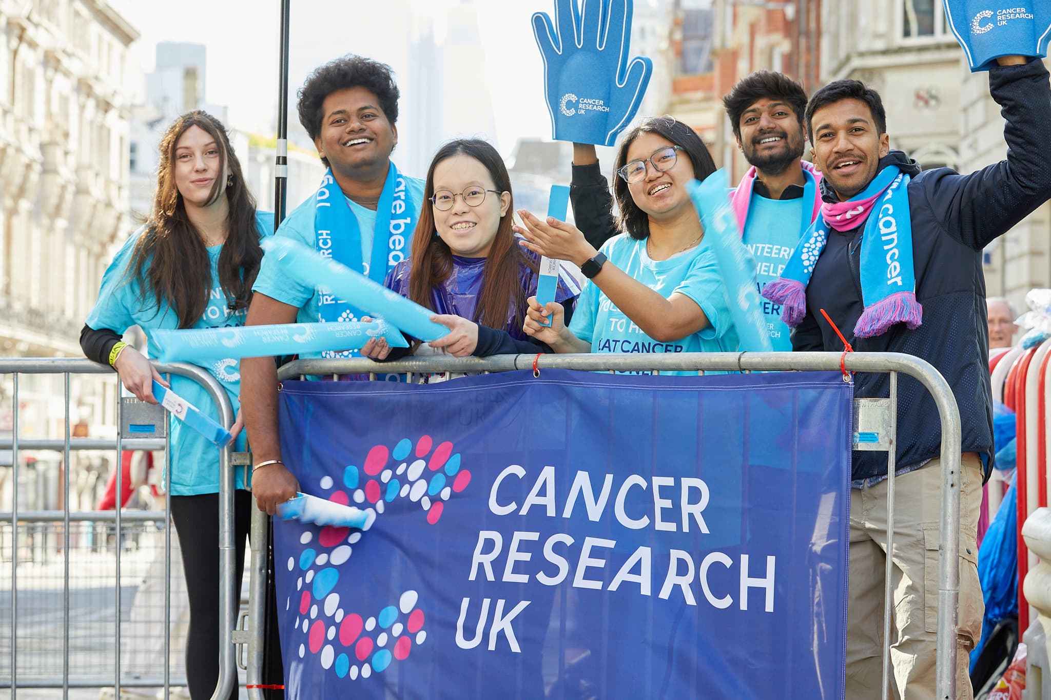 A group of six volunteers cheering and waving.