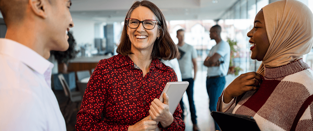 Three people standing in a room, smiling.