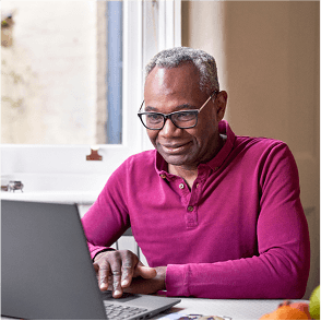 A photo of a man looking at his laptop.