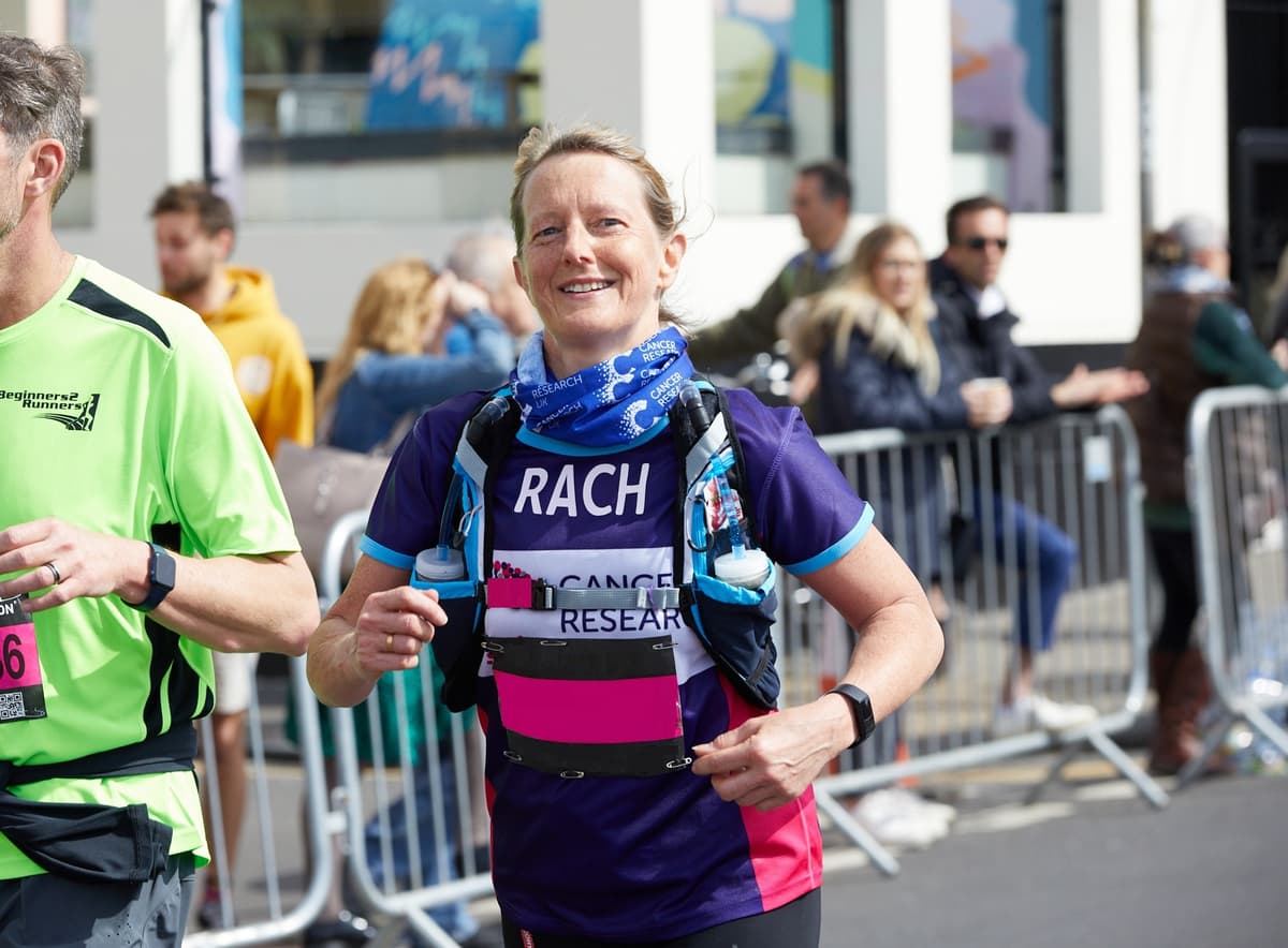 A Cancer Research UK Brighton Marathon runner, smiling.