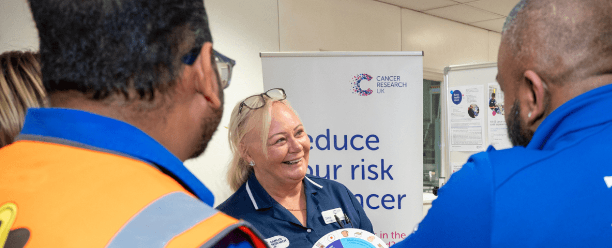 Two employees and a Cancer Research UK nurse discuss cancer awareness.