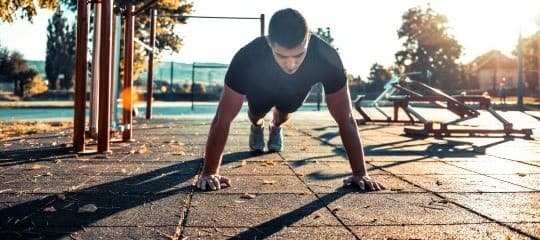 man doing push ups outside.
