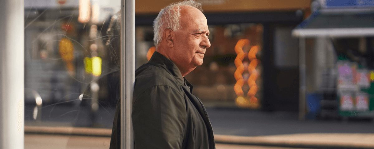 A man stands at a bus stop.