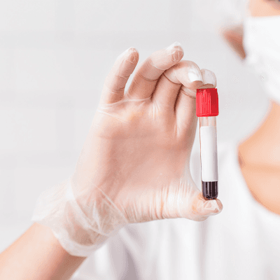 Image of researcher's hand holding a blood smaple tube.