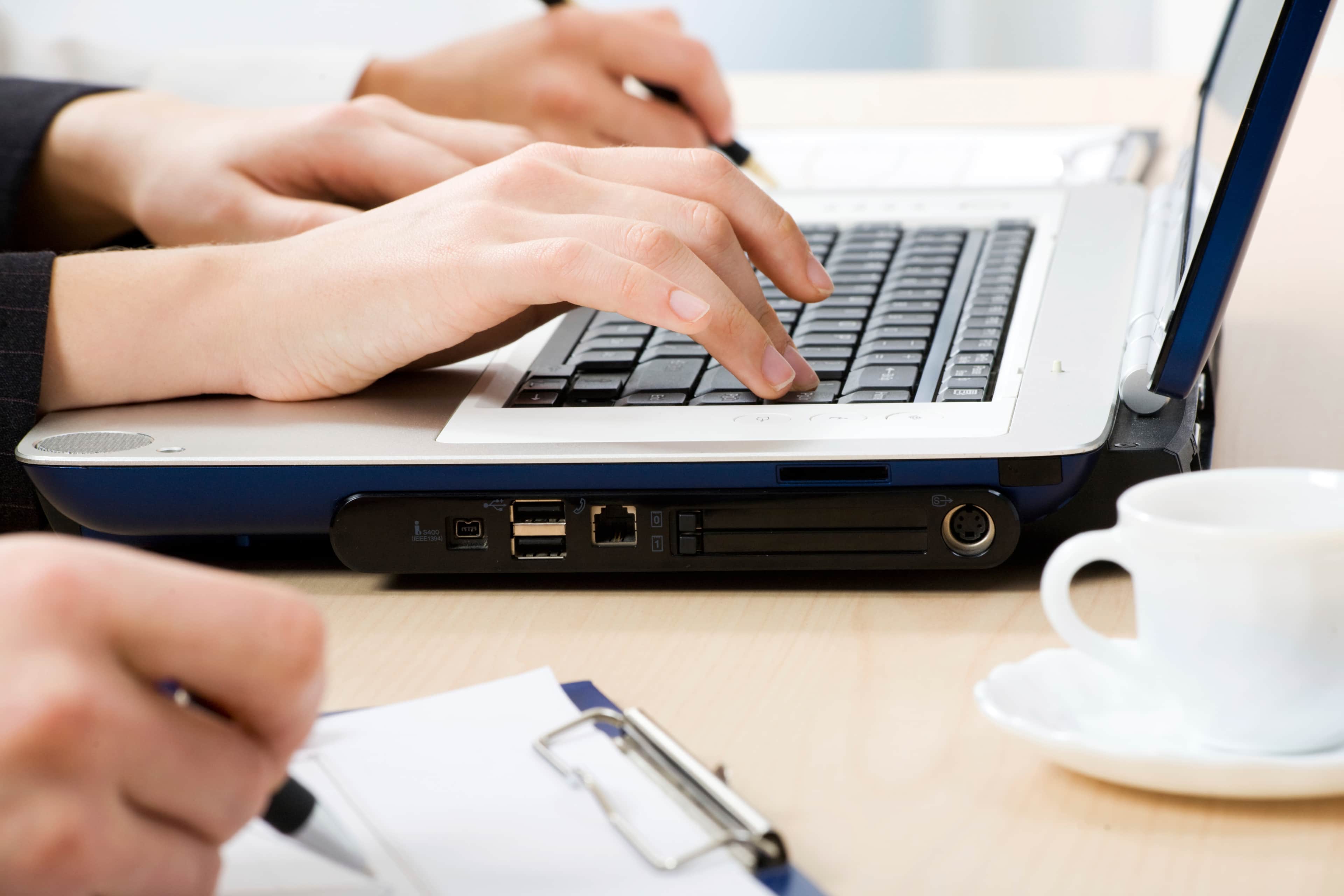 A pair of hands typing on a laptop.